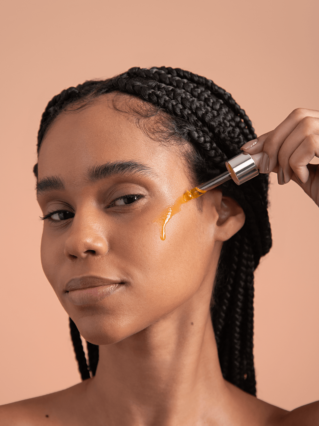Model dripping brightening berry vitamin c facial oil on face