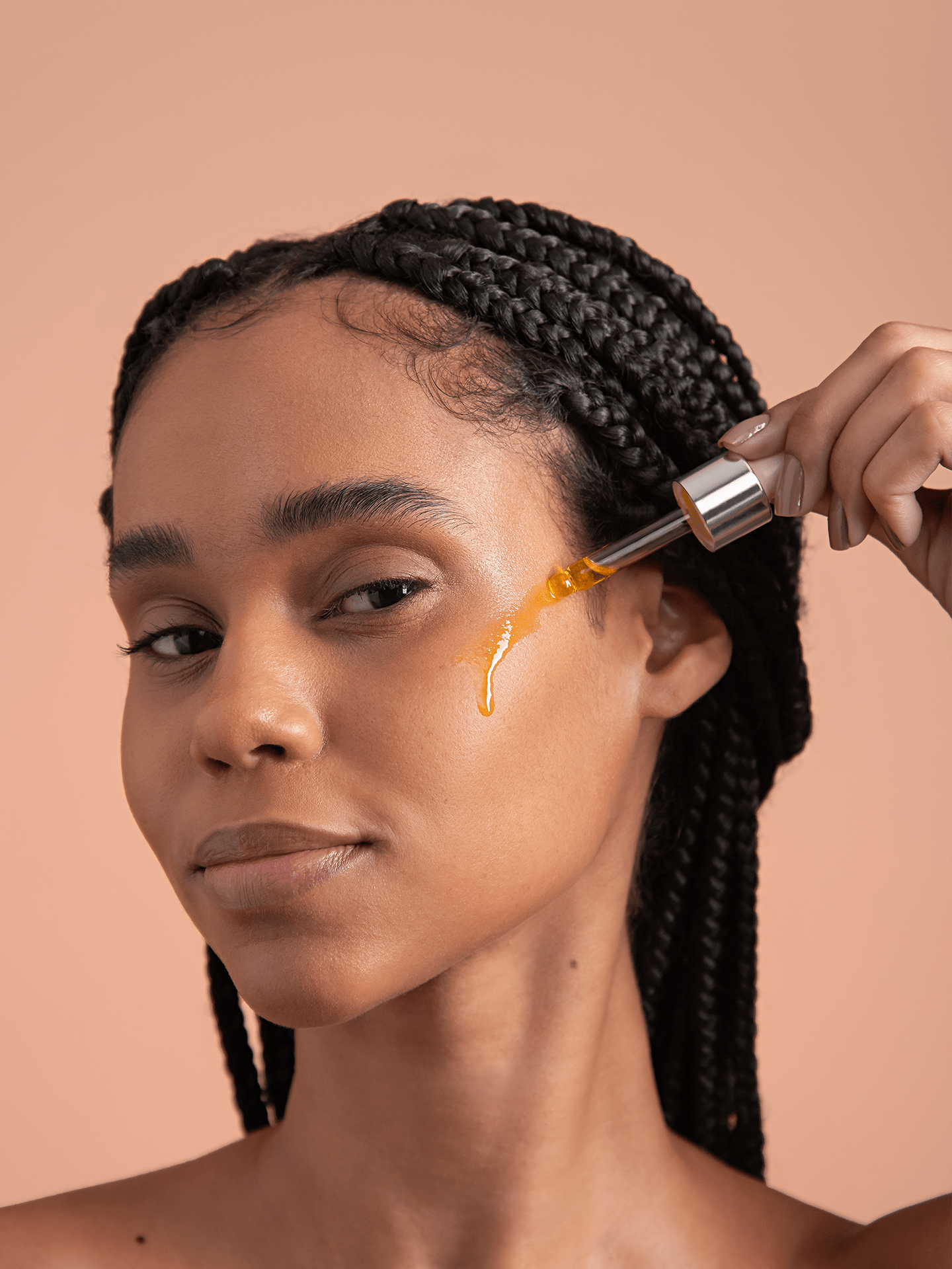 Model dripping brightening berry vitamin c facial oil on face
