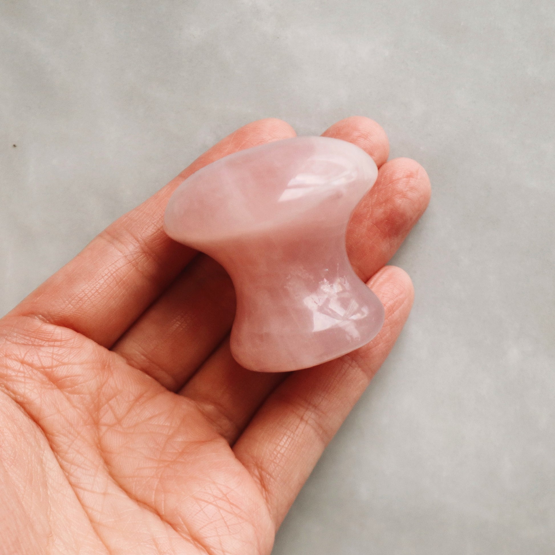 Woman holding Rose Quartz De-Puffing Eye Massage Tool 